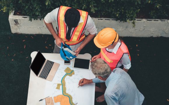 Engineers reviewing blueprints on site